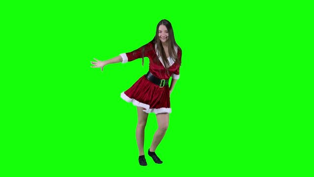 Jumping woman 20s in red Santa Christmas dress dancing spinning and dancing around having fun expressive gesticulating hands isolated on green screen background studio. Happy New Year holiday concept