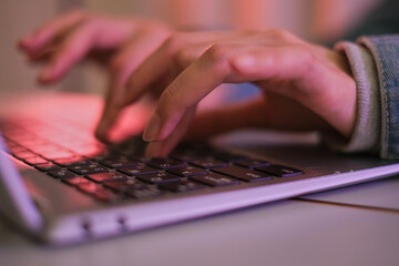 パソコンのキーボードを打つ女性の手元のクローズアップ