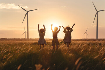 children playing in a field with wind turbines at the background, sustainable energy future clean energy concept; playful kids running in the countryside enjoying eco technology and pure air - obrazy, fototapety, plakaty