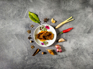 Rendang or Randang Indonesian food most delicious food in the world with various herb and spices and abstract background. With copy space.