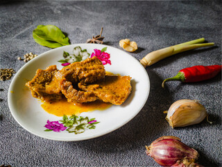 Close up Rendang or Randang Indonesian food most delicious food in the world with various herb and spices and abstract background. With copy space.