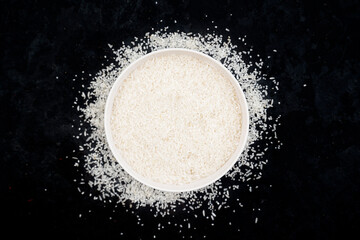 Healthy food. Bowl of white rice grains on black background