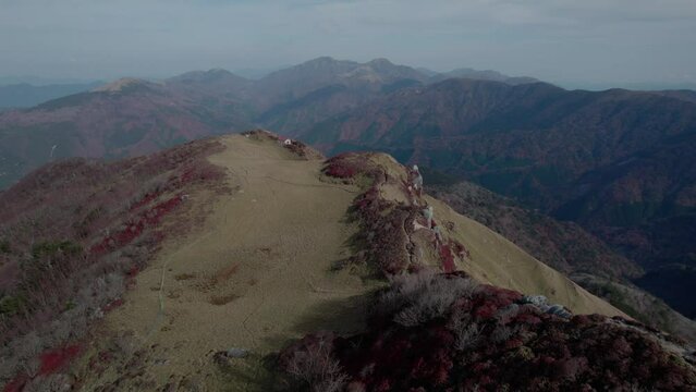Drone flight over the Miune mountain in Shikoku, Japan. The mountain shows a high contrast with red and green vegetation