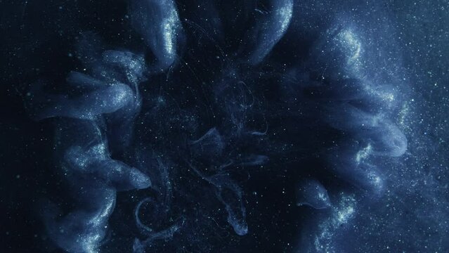 Vertical video. Ink explosion background. Magic spell. Blue glowing smoke swirls hypnotic burst cloud spreading in dark abstract glitter fume haze creative art.