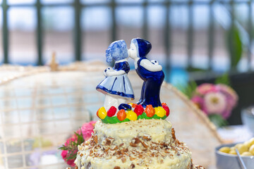 wedding cake and party decorations outdoors, dutch figurine boy and girl kissing blue.