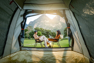 Tourist and tent in camp among with mountain view on sunset. View from tent camping on Beautiful...