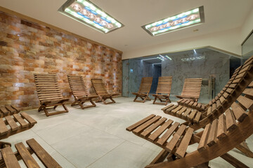 interior of modern wellness salt haloper cave with uv light with wooden bench - obrazy, fototapety, plakaty