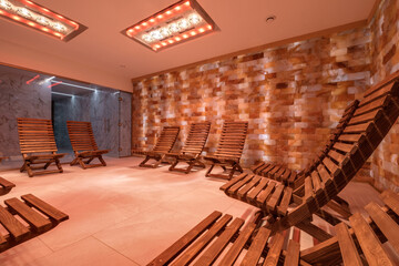 interior of modern wellness salt haloper cave with uv light with wooden bench - obrazy, fototapety, plakaty