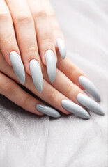 Grey nails on grey lace background.