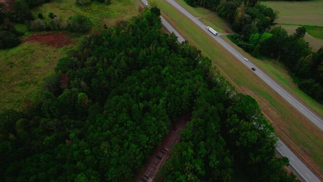 Semi-truck on forest-lined road, aerial view captures the essence of rural transport. Alabama USA