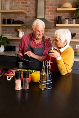  Happy caucasian senior couple preparing vegetables, drinking wine and using tablet, copy space © wavebreak3