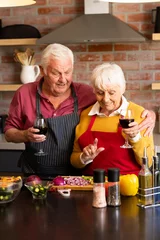  Happy caucasian senior couple preparing vegetables, drinking wine, embracing in kitchen, copy space © wavebreak3