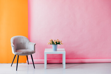 Interior of a pink room with colored chairs, armchairs