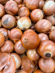 Fresh onions on the market close up photo. Onions big Golden on the counter market.