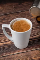 Fotobehang Cinnamon sprinkled salep in a white cup on wooden table © yalcinsonat