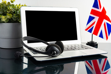 Online education concept with UK flag next to a laptop