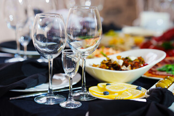 Empty wine glasses on a table with a black tablecloth. 