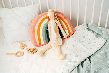 Wooden white baby crib and toy rabbit close up - obrazy, fototapety, plakaty
