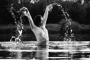 Happy blonde woman having fun in sunny park smiling, fooling around, laughing. Slow Motion. Beautiful caucasian girl dancing under the summer rain. wet hair and clothes. enjoying with drops.