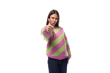 pretty positive cheerful young european brunette woman dressed in a striped pink-green pullover on a white background with copy space