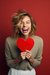 Portrait of a happy woman with red heart on a red background.Valentine's Day Concept