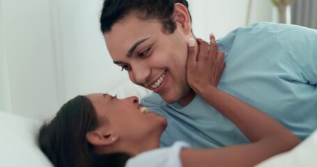 Couple, bed and kiss with love, care and morning on holiday, romance and happy in home together. Young man, woman and smile with embrace, trust and intimate in house, apartment and talking in bedroom