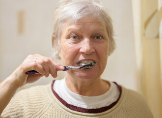 Aged woman brushes her teeth. - 678026702