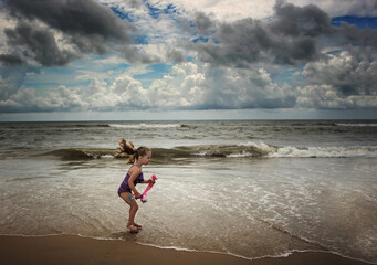 Little girl with pig tails blowing at the beach