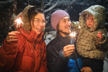 A family with a child celebrates the New Year together, burning