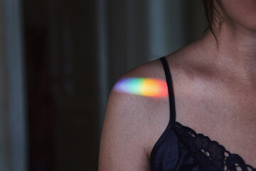 Rainbow sun glare on a woman's shoulder