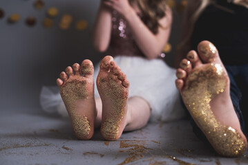 Close up photo of a young girl's bare feet covered in gold glitter