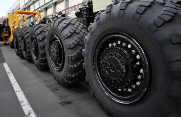 Heavy wheeled tires tractor on assembly line of the plant for transport non-standard cargo unusual...
