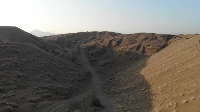 Sand hills in Oman with Hajar Mountains background