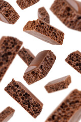 Levitation of cubes of milk porous chocolate isolated on a transparent background.