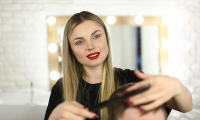 Young Hairdresser Styling Male Haircut with Hairbrush. Woman Hairstylist Combing Man Hair. Girl Barber Making Hairdo for Client in Beauty Salon. Professional Blonde Beautician Work in Studio