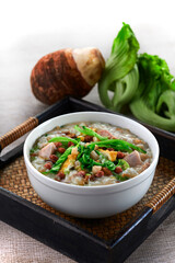 traditional chinese healthy braised porridge peanut congee rice seafood scallop fish century egg vegetable in bowl on grey vintage background cafe hotel luxury halal food restaurant banquet menu