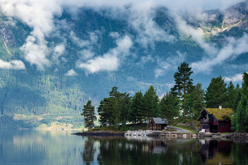Fototapeta premium Clouds and mountains reflecting on fjord in Norway