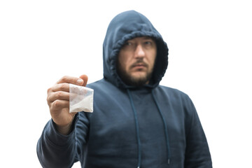 Criminal man in a hood holds transparent plastic bag with white powder hard drugs isolated on...