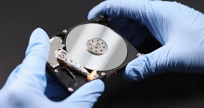 Gloved handyman holds computer hard drive. Hard disk recovery concept