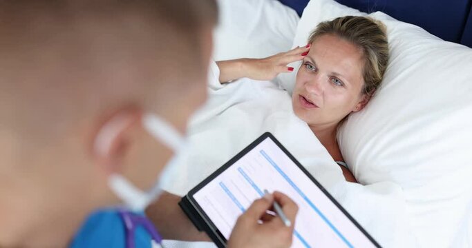 Male doctor conducts medical examination of woman lying in bed with headache and fever. Medical examination concept