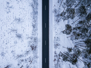 Aerial shot of a winter road in a forest