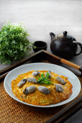 traditional chinese stir fried seafood fresh oyster with omelette egg in plate on grey vintage background asian cafe hotel luxury halal food restaurant banquet menu