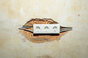 Electrical outlet in the wall of an old house, closeup