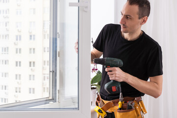 Close-up Of Young African Handyman In Uniform Installing Window