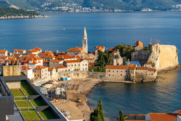 Montenegro Budva city old town red tiled roofs church tower and blue sea mountains in the background