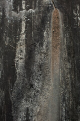 Black yellow rock texture. Mountain surface. Close-up. Gray stone background with copy space for design. Wide banner. Panoramic.