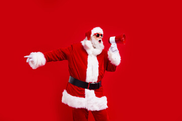 Fototapeta na wymiar Photo of crazy aged santa hold loudspeaker toa scream say tell new year offer isolated on red color background