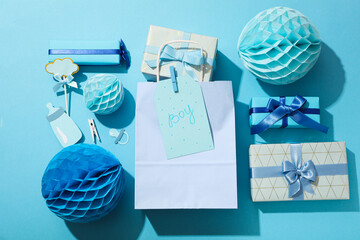 Gift boxes, paper balls and package on blue background, top view