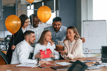 Celebration with cake, balloons and gift box. Employee having a birthday in the office, group of...