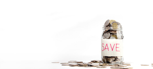 Coins in a glass jar on a white background with copy space. For saving money, financial concept